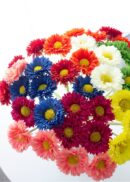 A pack of 10 Real Touch Gerbera Daisies in navy blue, each 17" tall, features closely arranged blooms on white stems set against a bright white background.