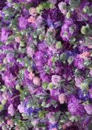 The 8x8ft Purple Lilac Eucalyptus Hydrangea Rose Flower Wall showcases purple, lavender, and pink blooms with lush green leaves for a vibrant display.