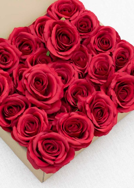 A box of 25 red 3.9" artificial roses with stems, arranged closely together against a white background.