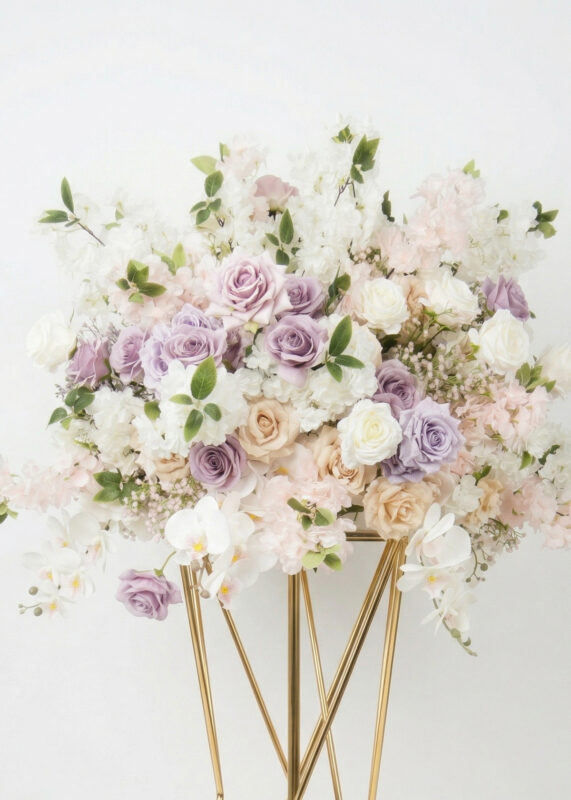 A 28in flower ball of pastel blooms, featuring light purple, white, and pale pink roses—plus mocha roses—mixed with greenery and white orchids on a gold metal stand against a plain white background.